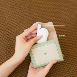 Small black clip-on LED book reading light with a flexible neck attached to a book, illuminating the pages.