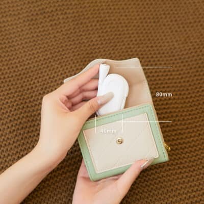 Small black clip-on LED book reading light with a flexible neck attached to a book, illuminating the pages.