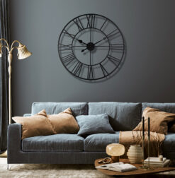 Decorative 80cm metal skeleton wall clock in a distressed black finish, showing the wall through its design.